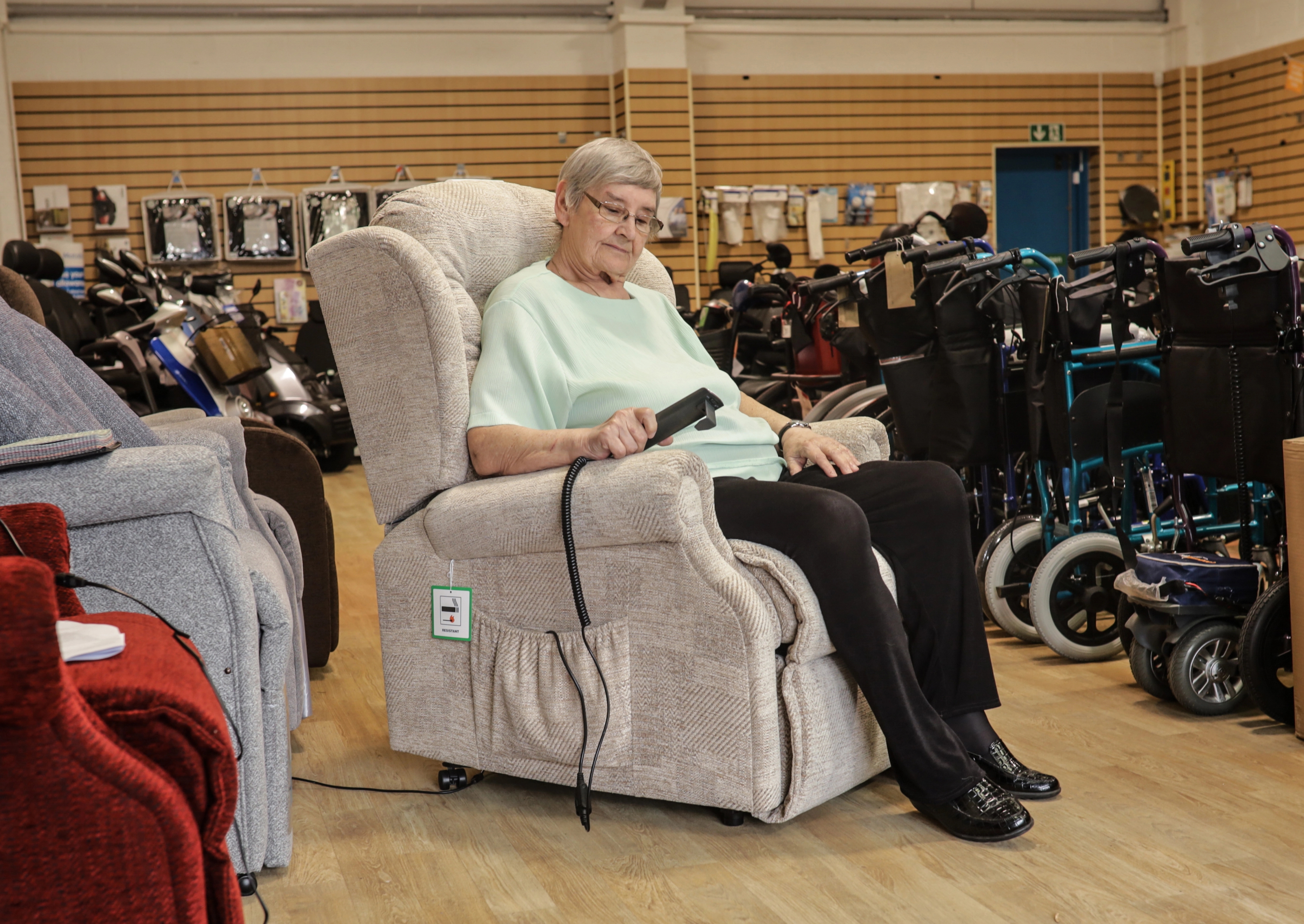 A lady sat in a high-back mobility bed in a mobility furniture showroom