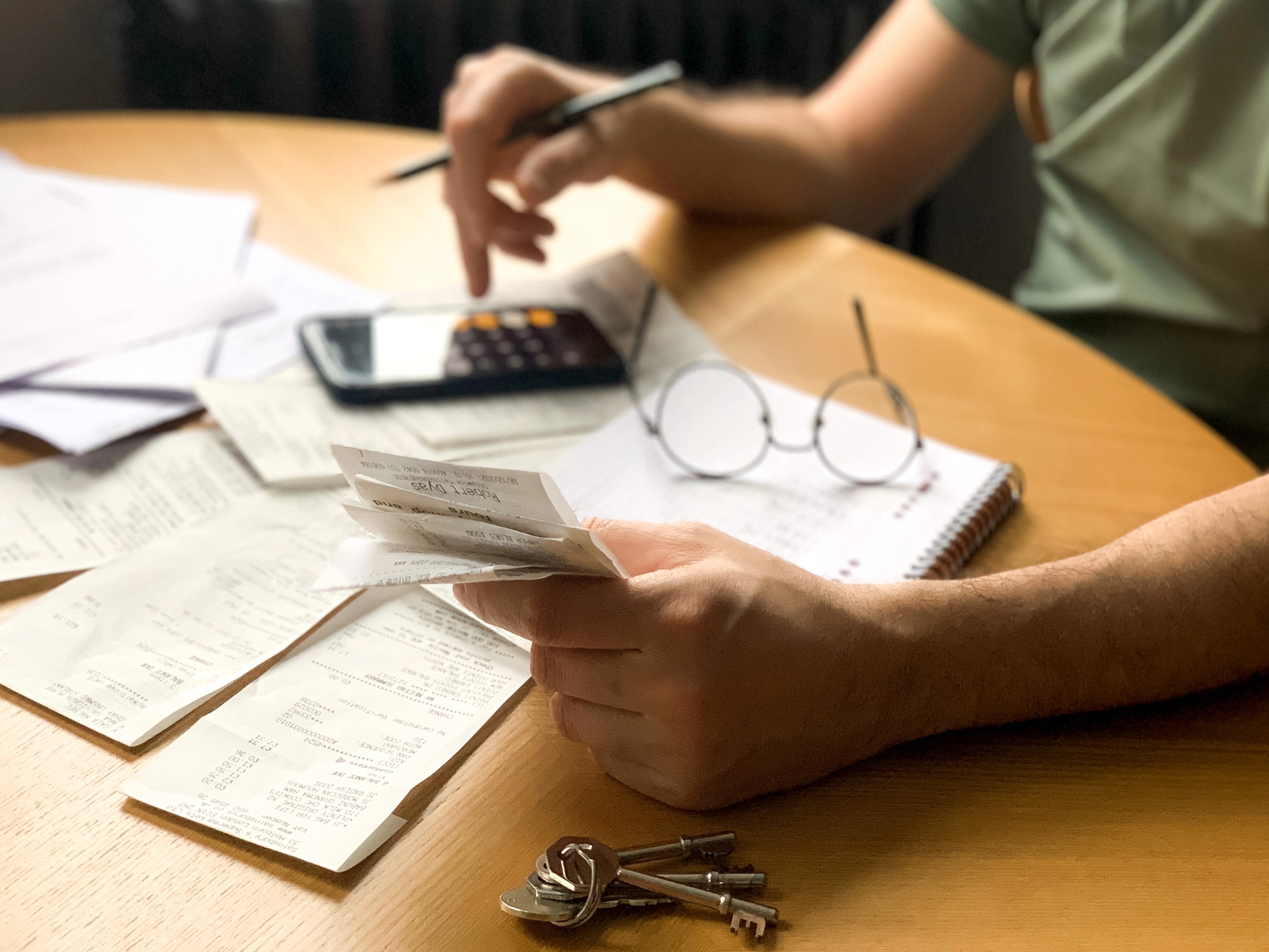 Someone calculating bills or costs with paperwork