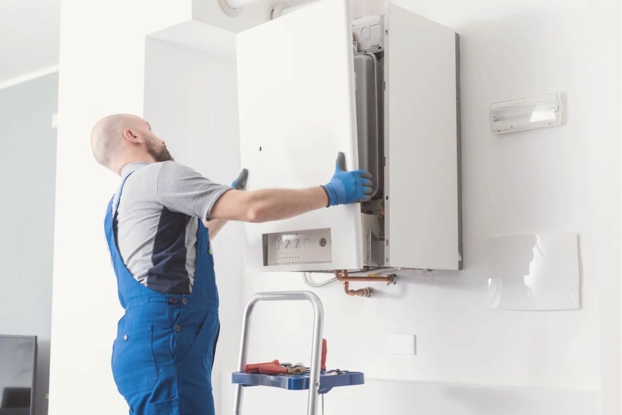 A man fitting a boiler with a cover