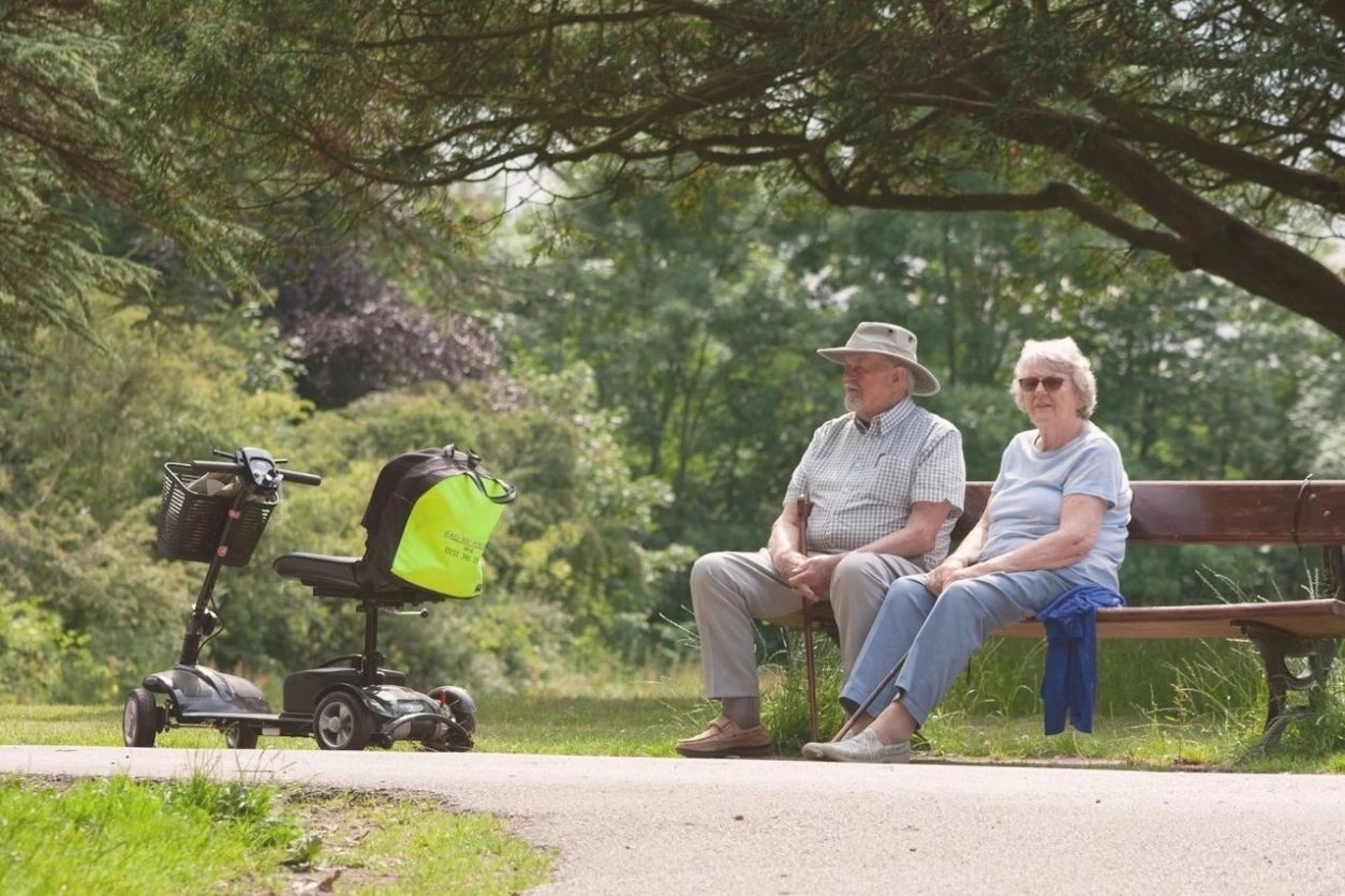 sat-on-park-bench-with-mobility-vehicles