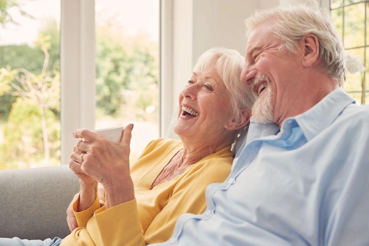 A couple laughing and enjoying time together on a sofa