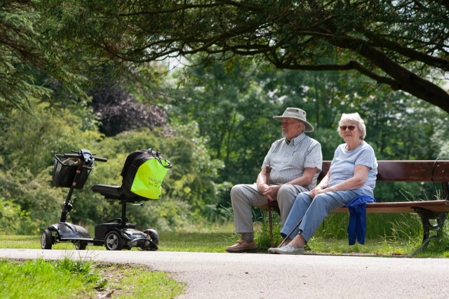 Elderly couple sitting on park bench