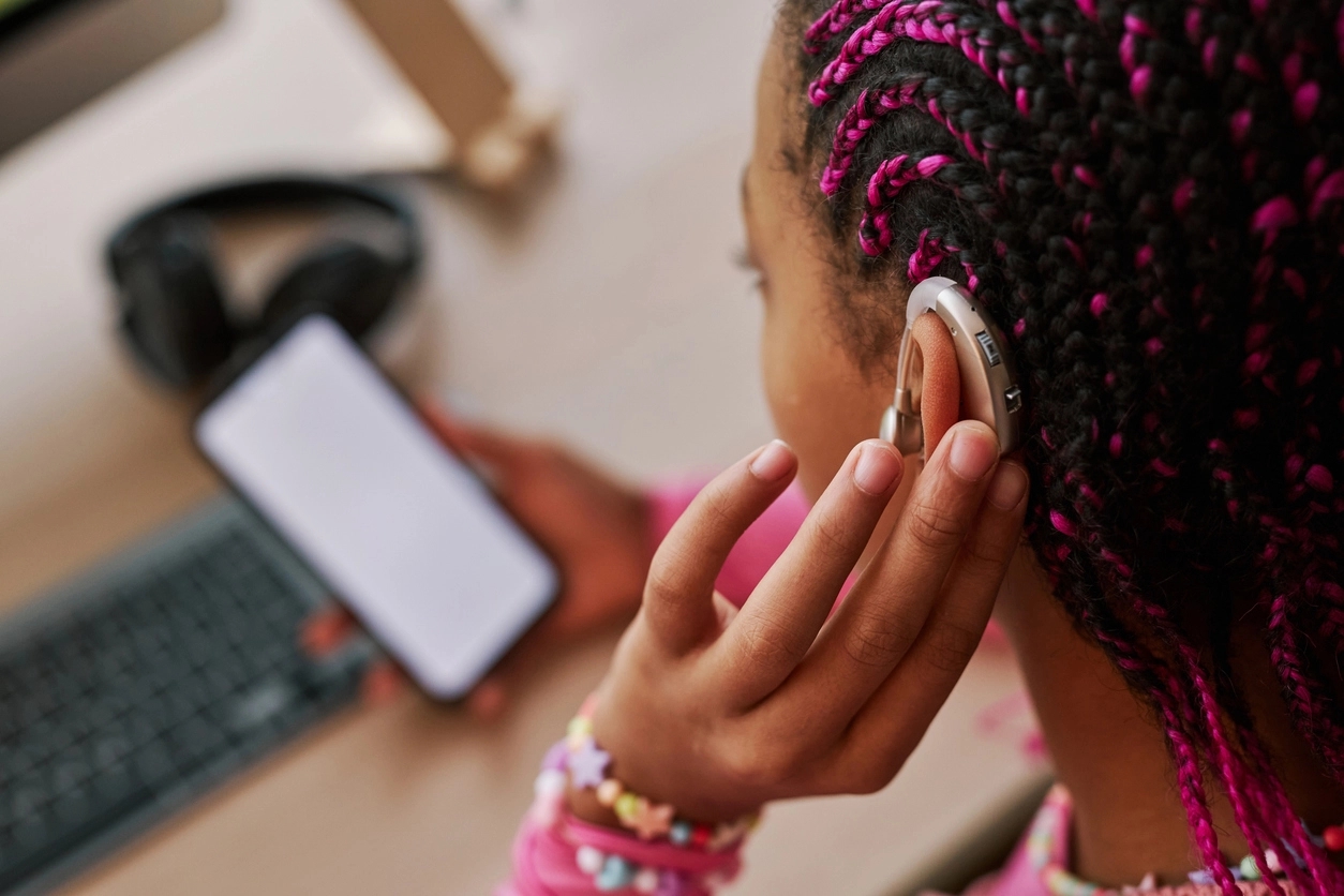 Black teenage girl wearing hearing aid