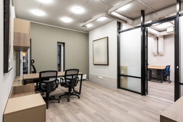 A commercial office space with a desk and two chairs